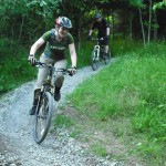 Two riders on mountain bike trail.