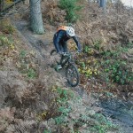 Rider going down a muddy ramp in Forest of Dean.