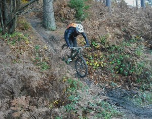 Rider going down a muddy ramp in Forest of Dean.