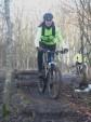 Woman riding down a log feature at Croft Trail, Swindon.