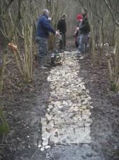 Trail builders with smashed slabs and compacter.