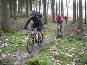 Mountain bike rider going down steep ramp.