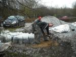 Volunteers loading gravel into bags.