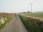 Cyclist on road near Kingscote in the Cotswolds.