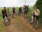 Group of mountain bikers standing by a gate.