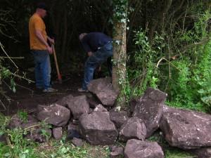 Digging rocks out of the ground.