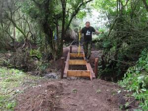 Partially built bridge over river at mountain bike trail.