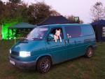 Bulldog leaning out of window of van.