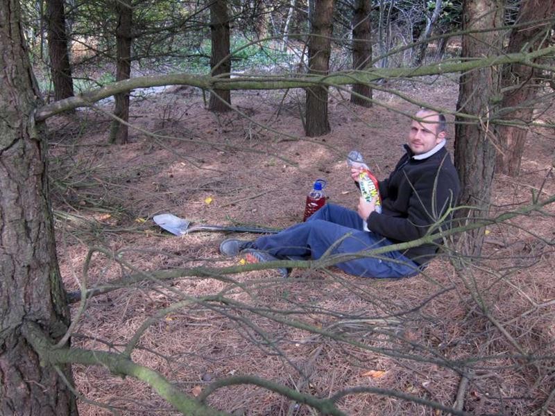 Man eating picnic in woods.