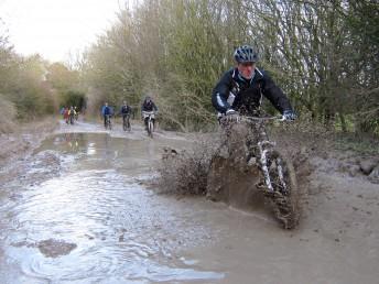 Mountain biker riding through massive puddle near Marlborough.