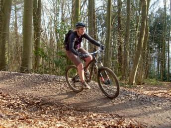 Women mountain biker on berm at Ashton Court.