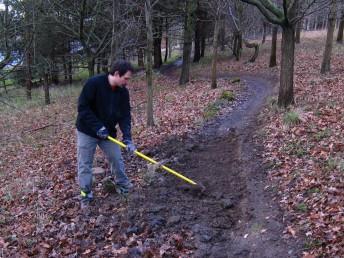 Raking mud at mountain bike trail.