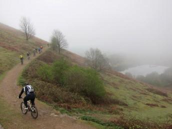 Mountain bikers on a misty Malvern hill.