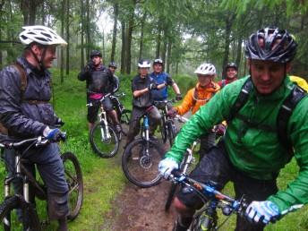 Wet mountain bikers in the Forest of Dean.