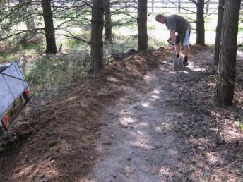 Building  a berm up at a mountain bike trail.