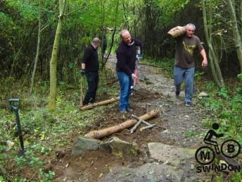 Moving logs at a mountain bike trail.